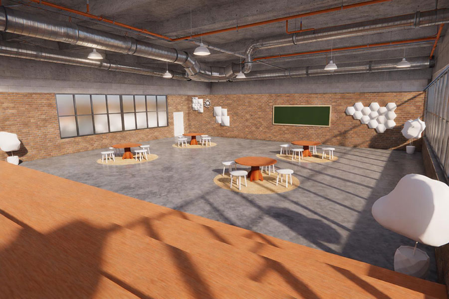 An industrial-style classroom or workshop space featuring exposed concrete ceilings with prominent HVAC ductwork and brick walls.