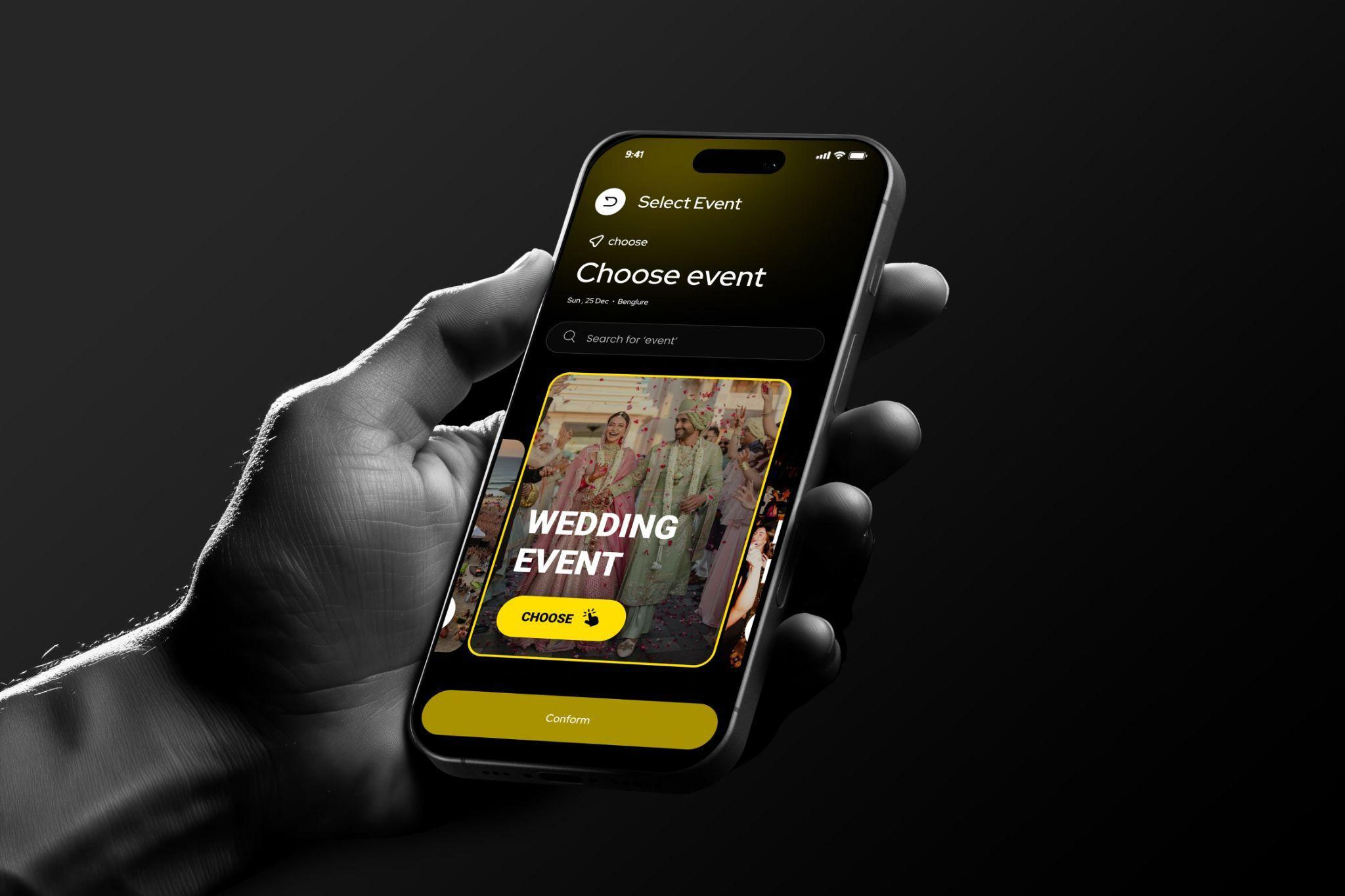 A mobile app interface for selecting events, held in a hand and featuring a dark-themed design with bold yellow accents.