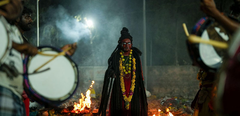 Encircled by drums and fire, the devotee stands at the threshold - where rhythm becomes trance and faith becomes identity
